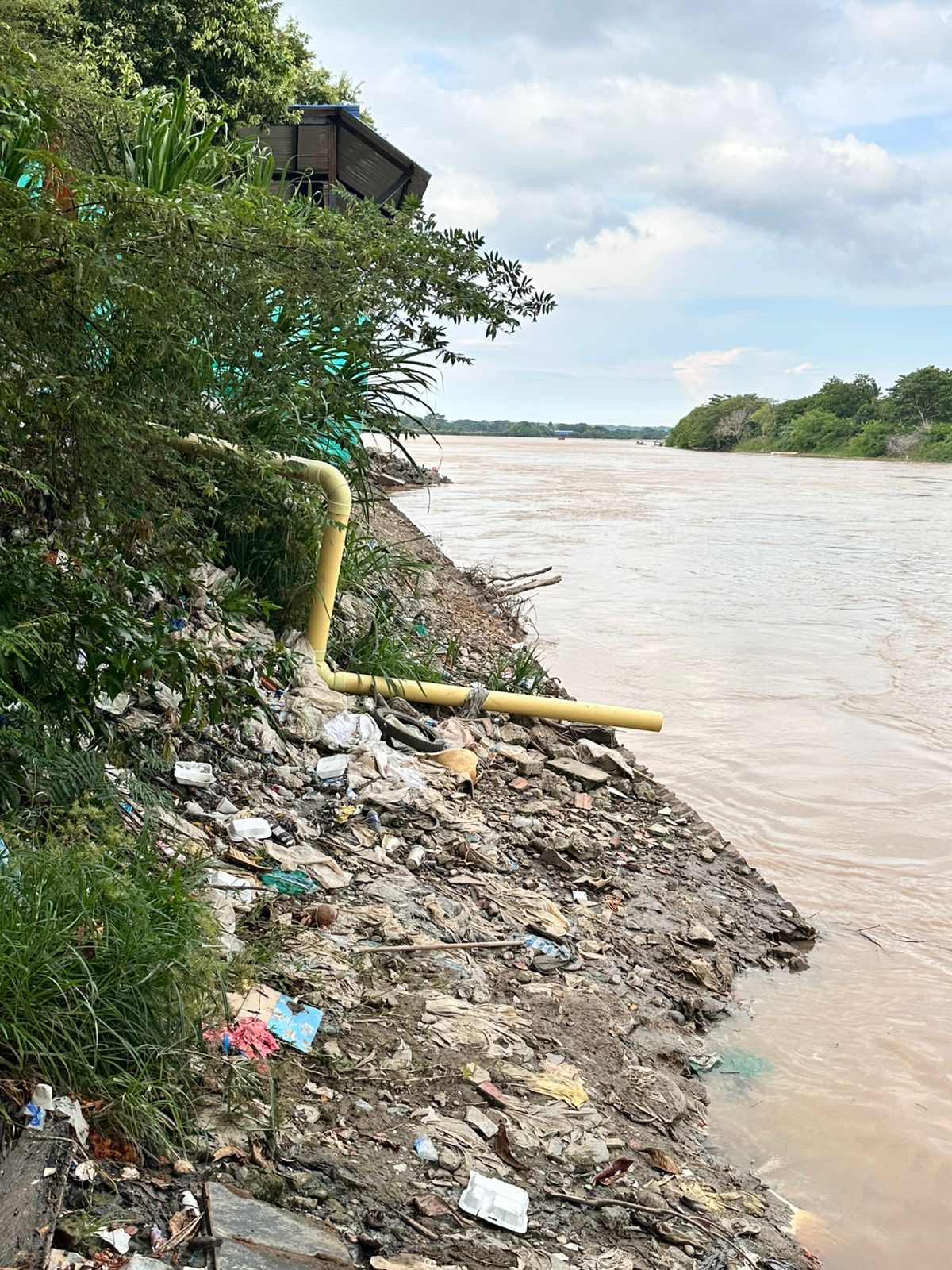 Pipe and waste beside the river